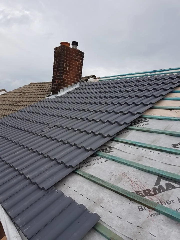 Roofer replacing broken tiles on a Surrey terraced house